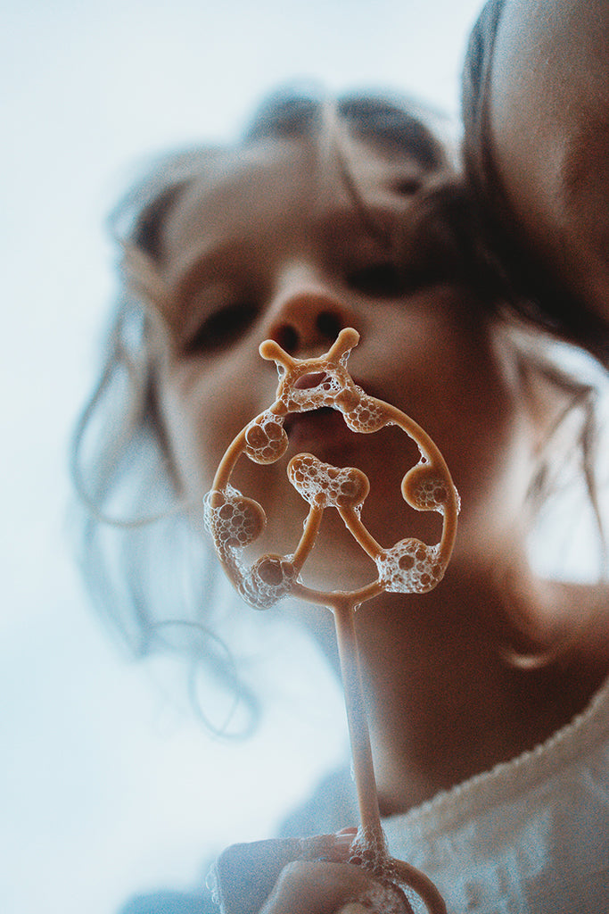 Friends are blowing bubbles through the ladybird eco bubble wand from Kinfolk Pantry.