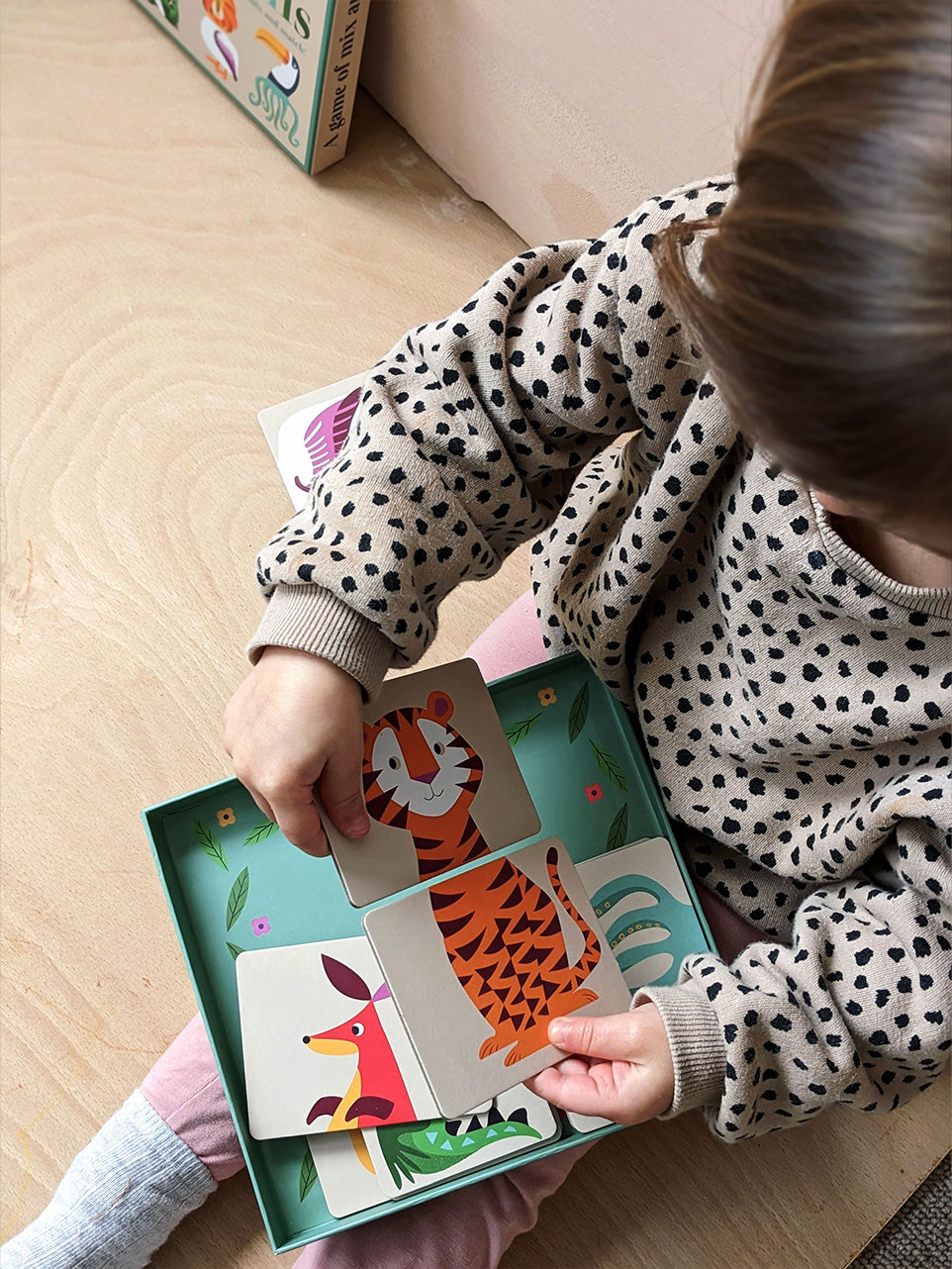 Toddler plays an animal heads and tails matching card game